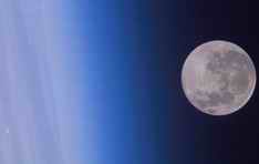 Full Moon hovering above Earth's atmosphere